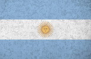 Argentina flag depicted in bright paint colors on old relief plastering wall close up